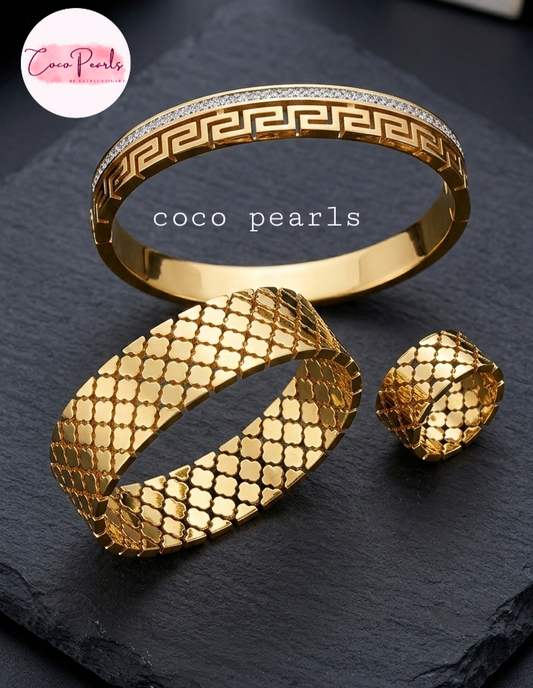 coco pearls stainless steel anti tarnish golden handcuffs and rings displayed on grey background