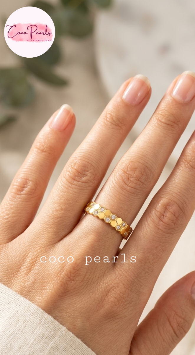 Coco pearls stainless Steel anti tarnish close-up of a hand wearing a gold ring with honeycomb design and stones on top