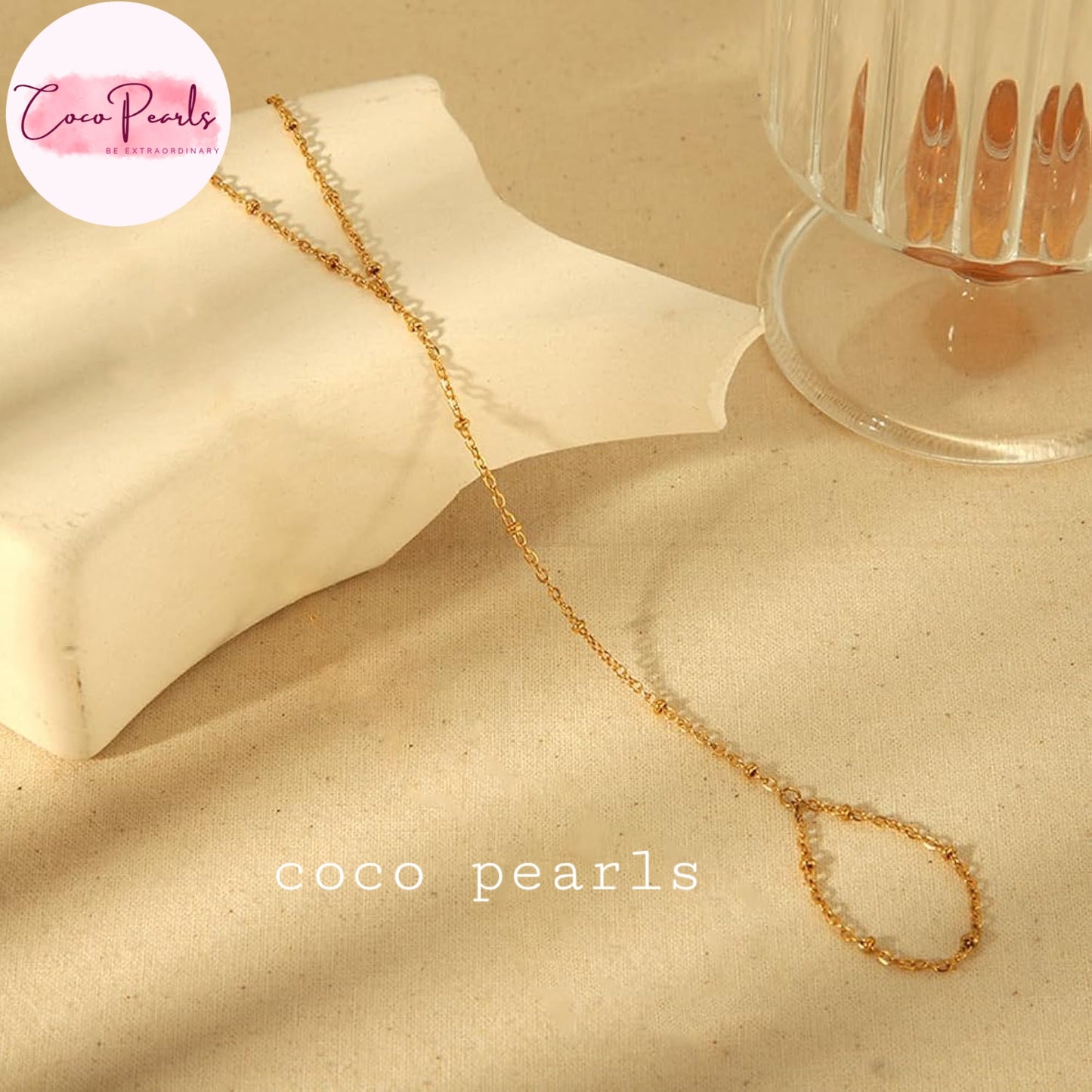 Coco pearls stainless Steel anti tarnish gold small ball chain hand harness displayed on simple background
