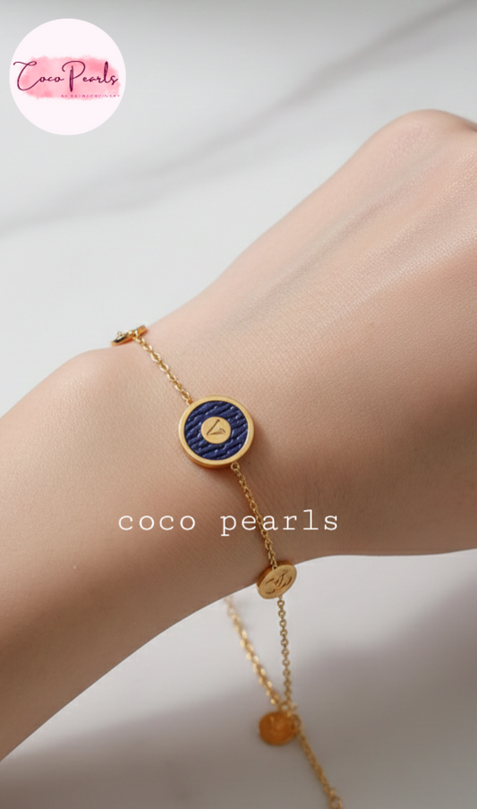 Coco Pearls Stainless Steel Anti tarnish Gold and brown v link bracelet with v initial on brown charm in center and golden charms on either side displayed on hand
