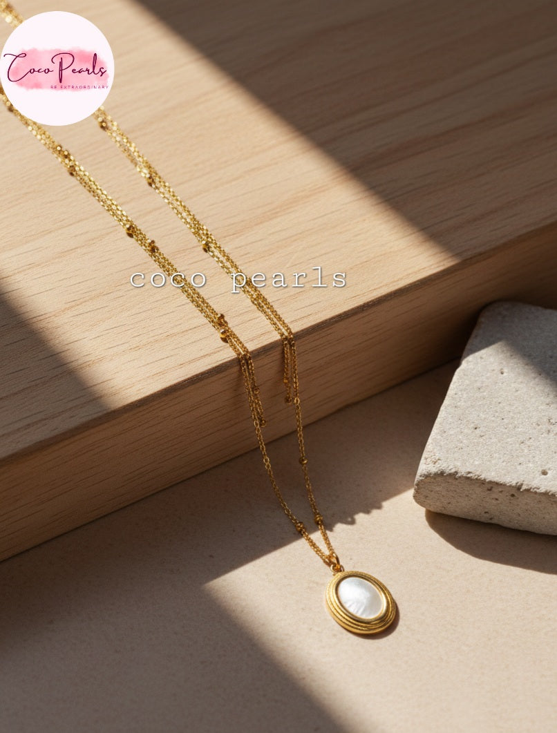 Coco Pearls Stainless Steel Anti Tarnish gold aurora necklace with with center in oval shape displayed on wooden plank