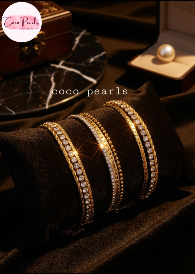 Coco Pearls Stainless Steel Anti tarnish Gold stack bracelets with rhinestones displayed on a black fabric