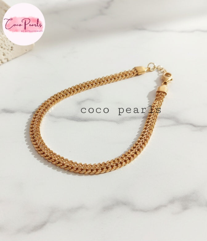 Coco Pearls Stainless steel anti tarnish "coco mesh" Gold chain bracelet on a white marble surface with 'Coco Pearls' branding.