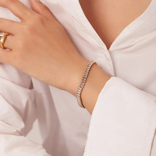 Coco Pearls Stainless Steel Anti Tarnish tennis bracelet. Close-up of a hand wearing a bracelet on a white fabric background