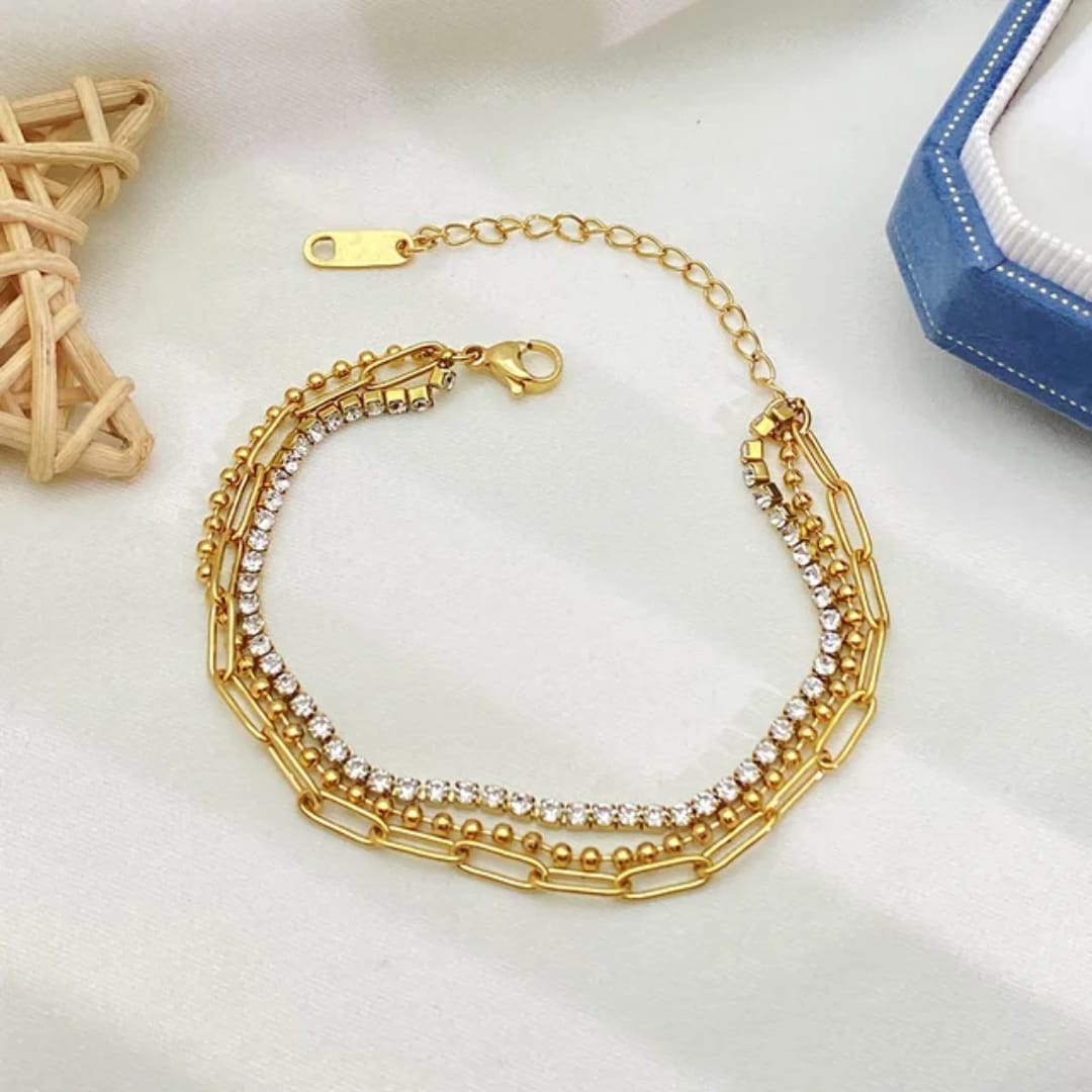 Coco Pearls Stainless Steel Anti Tarnish Gold dainty link bracelet with beads chain, loop chain and rhinestone chain on a white surface