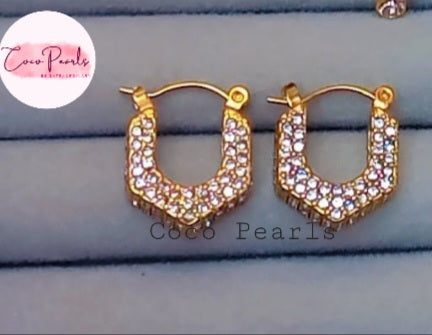Coco Pearls Stainless Steel Anti Tarnish Gold dazzling crescent hoop earrings. diamond studded hoop on a blue background