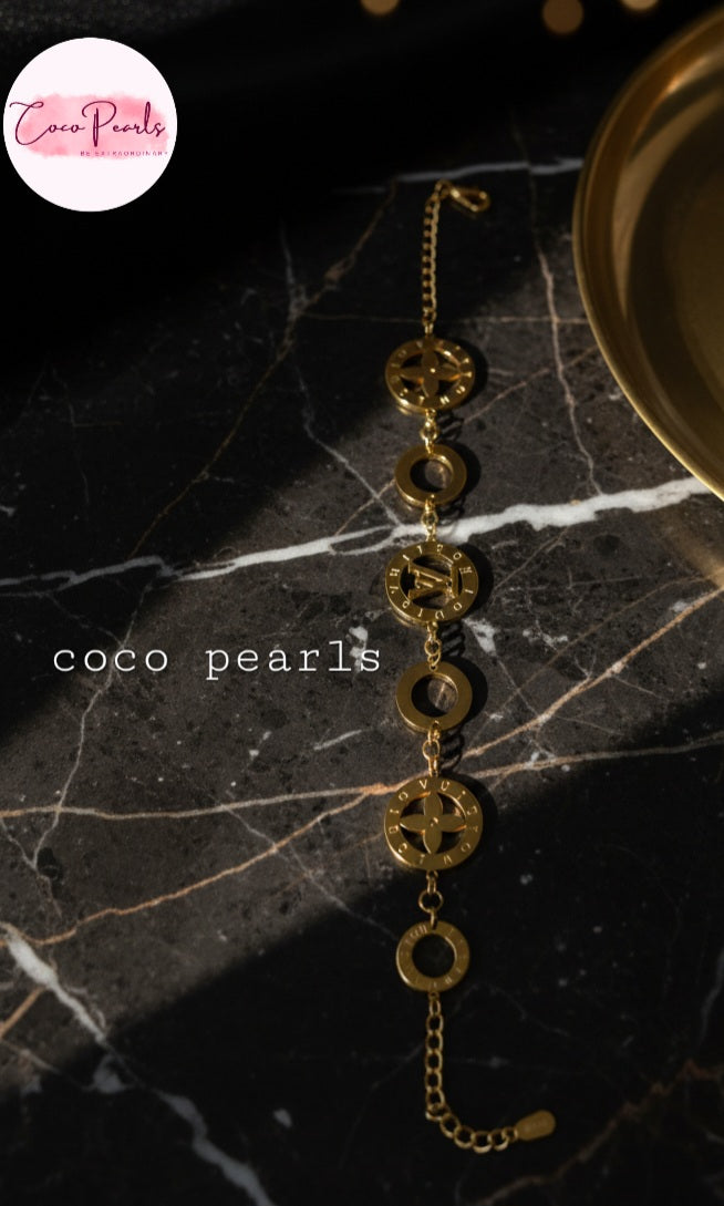 Coco Pearls Stainless steel anti tarnish Gold disc bracelet on a dark marble surface