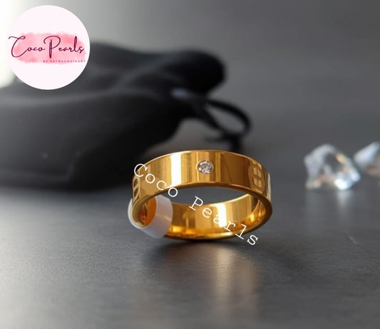 Coco Pearls Stainless Steel Anti Tarnish Gold elegance twist ring band with diamonds on a dark surface