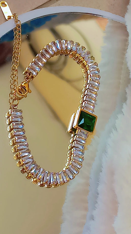 Coco Pearls Stainless steel "emerald glam" Gold bracelet with clear gemstones and a green gemstone on a white surface