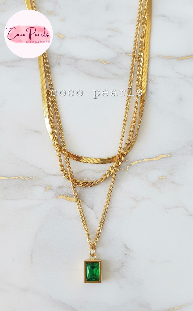 Coco Pearls Stainless Steel Anti Tarnish Gold emerald trio triple chain necklace with a green pendant displayed on marble surface