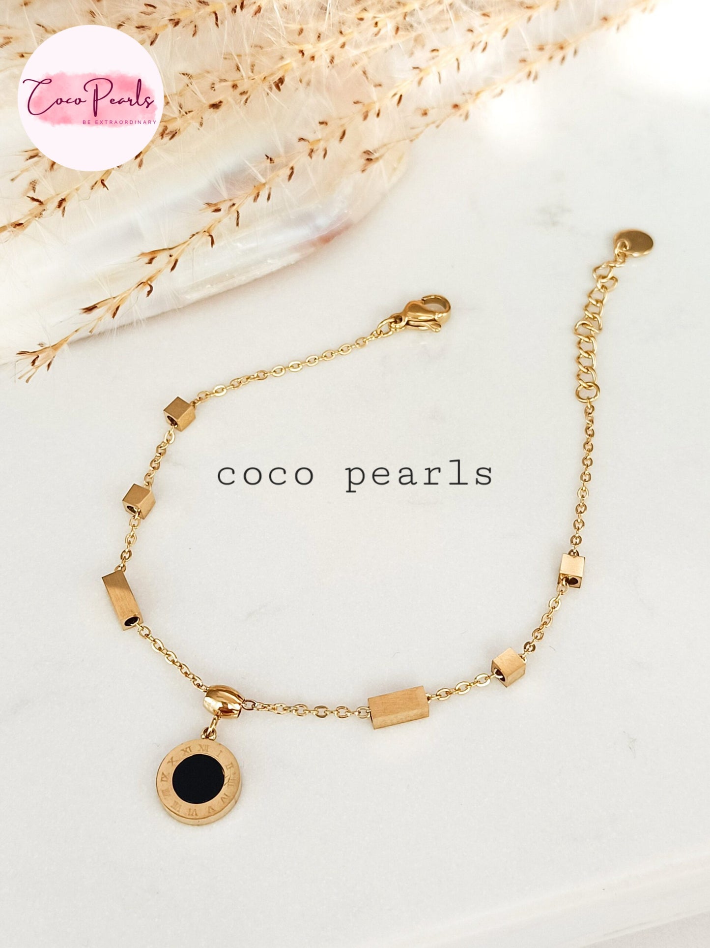 Coco Pearls Stainless steel anti tarnish Gold geometry bracelet with black gemstone hanging displayed on a white background,