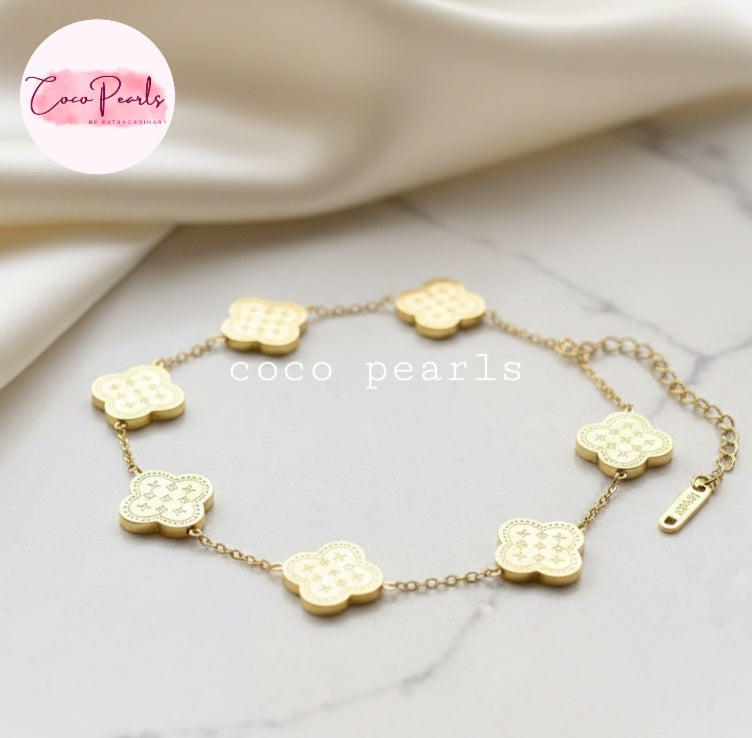 Coco Pearls Stainless steel Anti Tarnish Golden fortune bracelet with clover-shaped charms on a marble surface