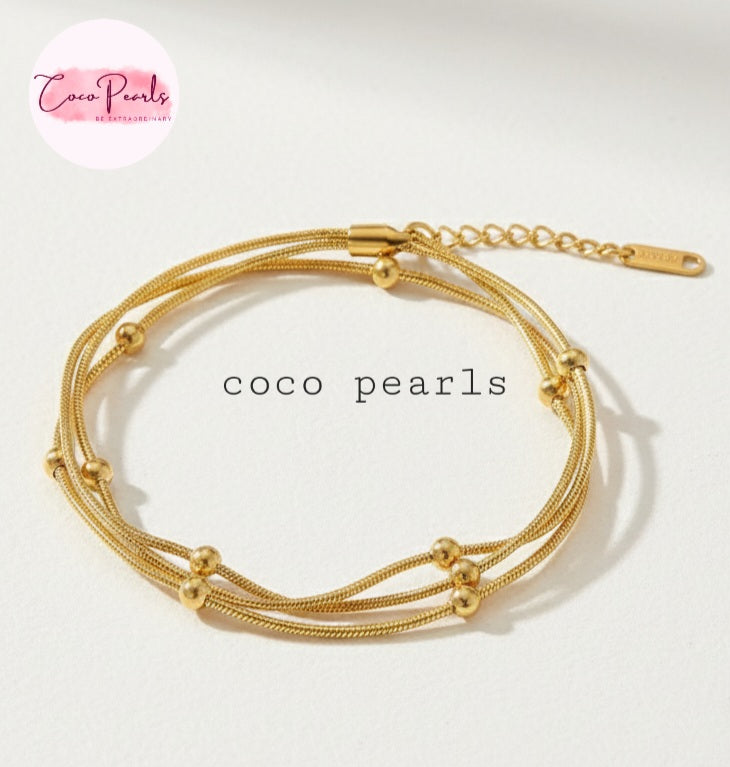 Coco Pearls Stainless steel Anti Tarnish Golden harmony three layer ball chain bracelet on a light background
