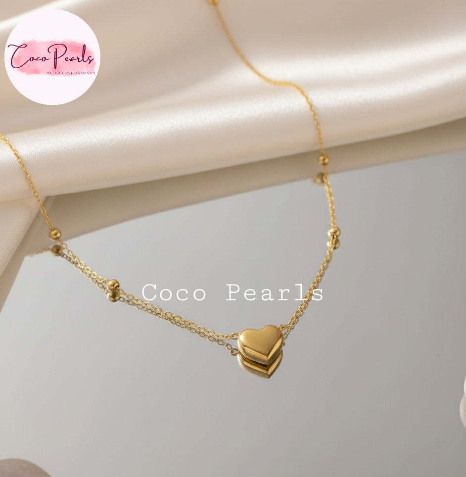 Coco Pearls Stainless Steel Anti Tarnish Gold heart desire necklace with heart pendants and ball chain on a light background