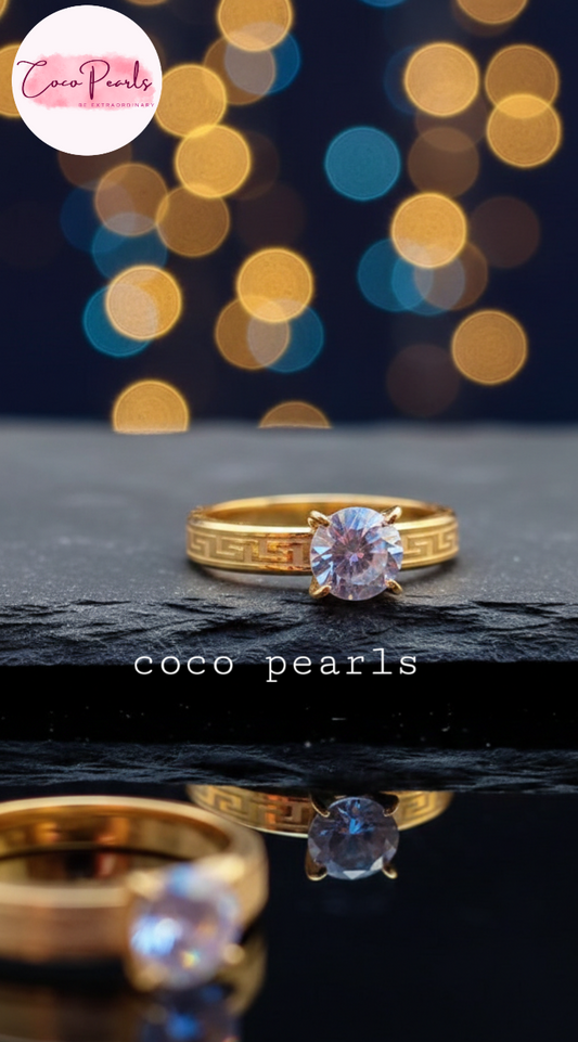 coco pearls stainless steel anti tarnish Gold luminous solitaire ring with a clear gemstone on a dark surface