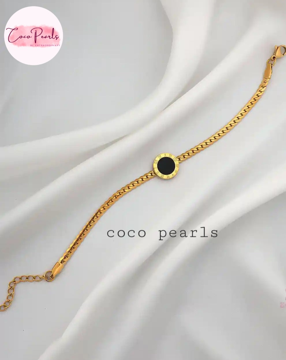 Coco Pearls stainless steel anti tarnish Gold midnight aura bracelet with black charm in center displayed on a white fabric background