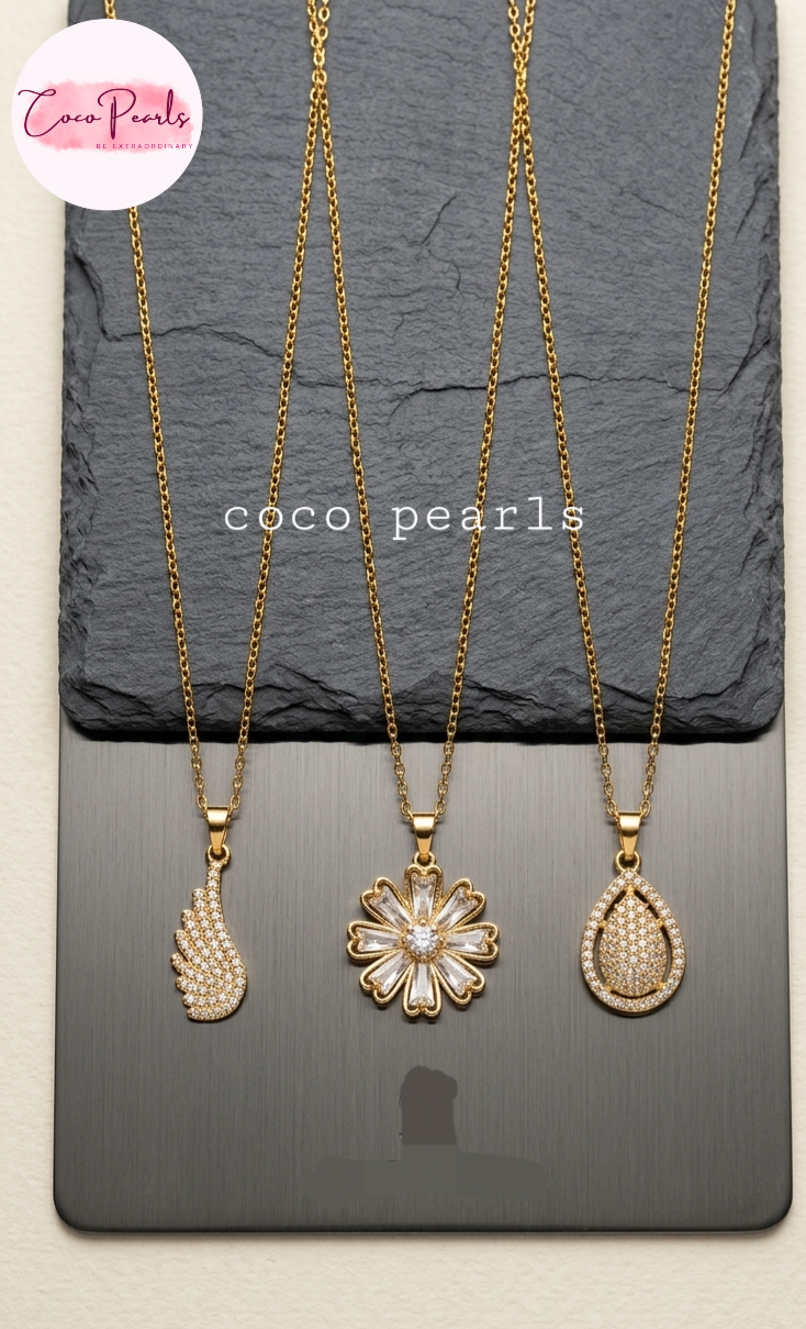 coco pearls stainless steel pakistan anti tarnish waterproof Three gold necklaces with pendants on a dark surface