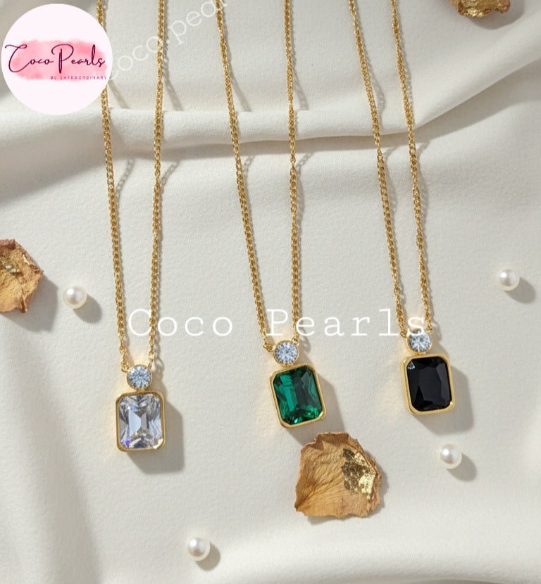Coco Pearls Stainless Steel Anti Tarnish Three gold necklaces with gemstone pendants in green, black and clear color on a white surface