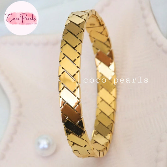 Coco pearls stainless Steel anti tarnish gold regal grid handcuff displayed on simple background