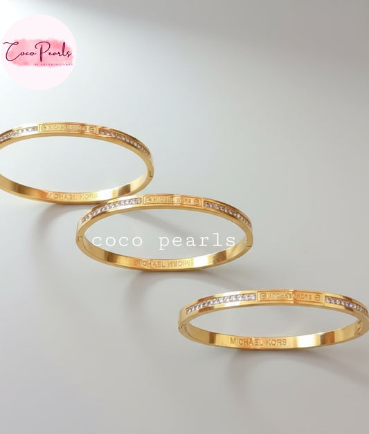 Coco Pearls Stainless Steel Anti Tarnish Gold Sparkle elegance handcuff bangle bracelet with diamond accents displayed on grey background