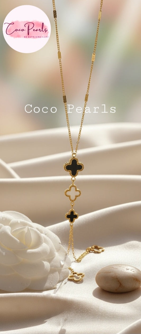 Coco Pearls Stainless Steel Anti Tarnish triple clover Gold necklace with black and white clover pendants and two gold clover hangings on a white surface, branded 'Coco Pearls'.