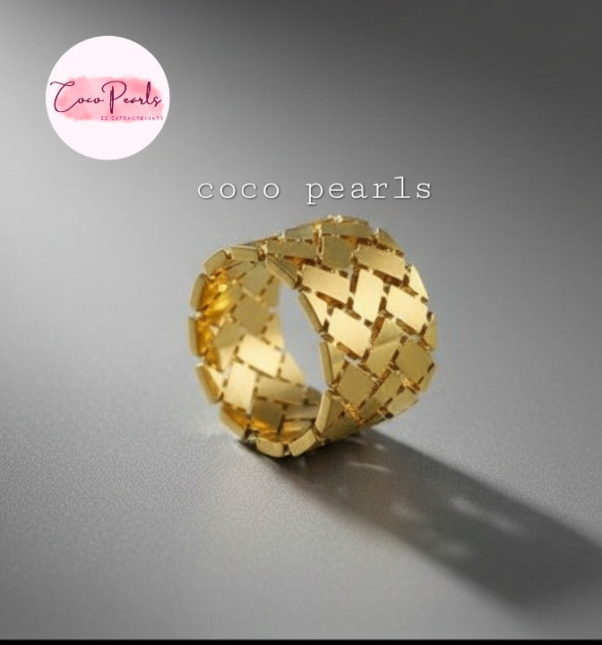 Coco Pearls Stainless Steel Anti Tarnish Gold woven glow ring on a wooden surface