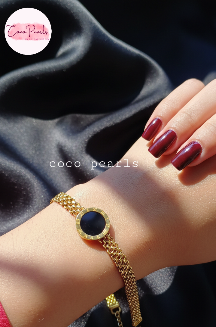 stainless steel anti tarnish Gold midnight aura bracelet with a black circle on a wrist