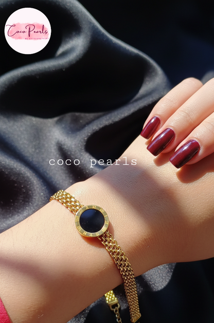 stainless steel anti tarnish Gold midnight aura bracelet with a black circle on a wrist