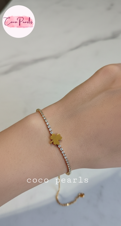 coco pearls stainless steel anti tarnish lucky charm bracelet. diamond studded with golden clover in center displayed on hand