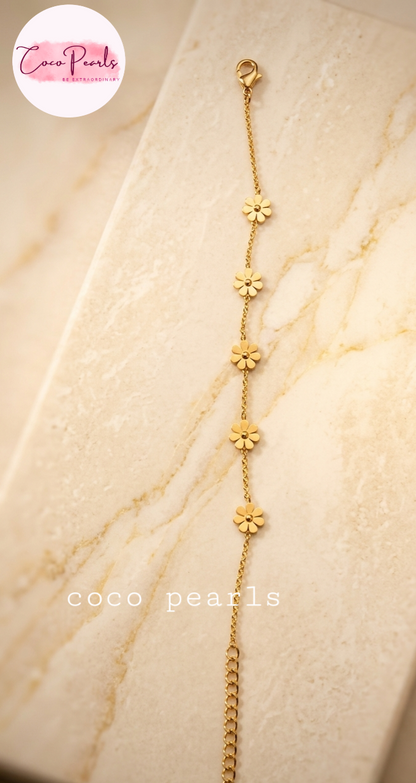 Coco Pearls Stainless steel anti tarnish Gold necklace with golden flower pendants on marble background.