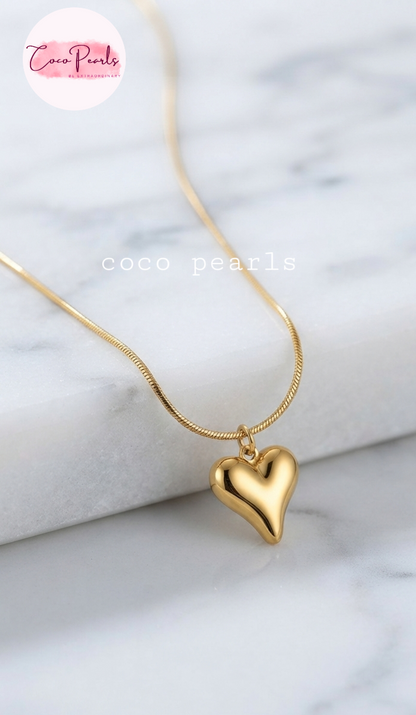 Coco pearls stainless Steel anti tarnish gold heart necklace displayed on simple background 