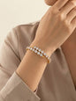 Coco pearls stainless Steel anti tarnish Gold bracelet with clear stones on a wrist against a neutral background