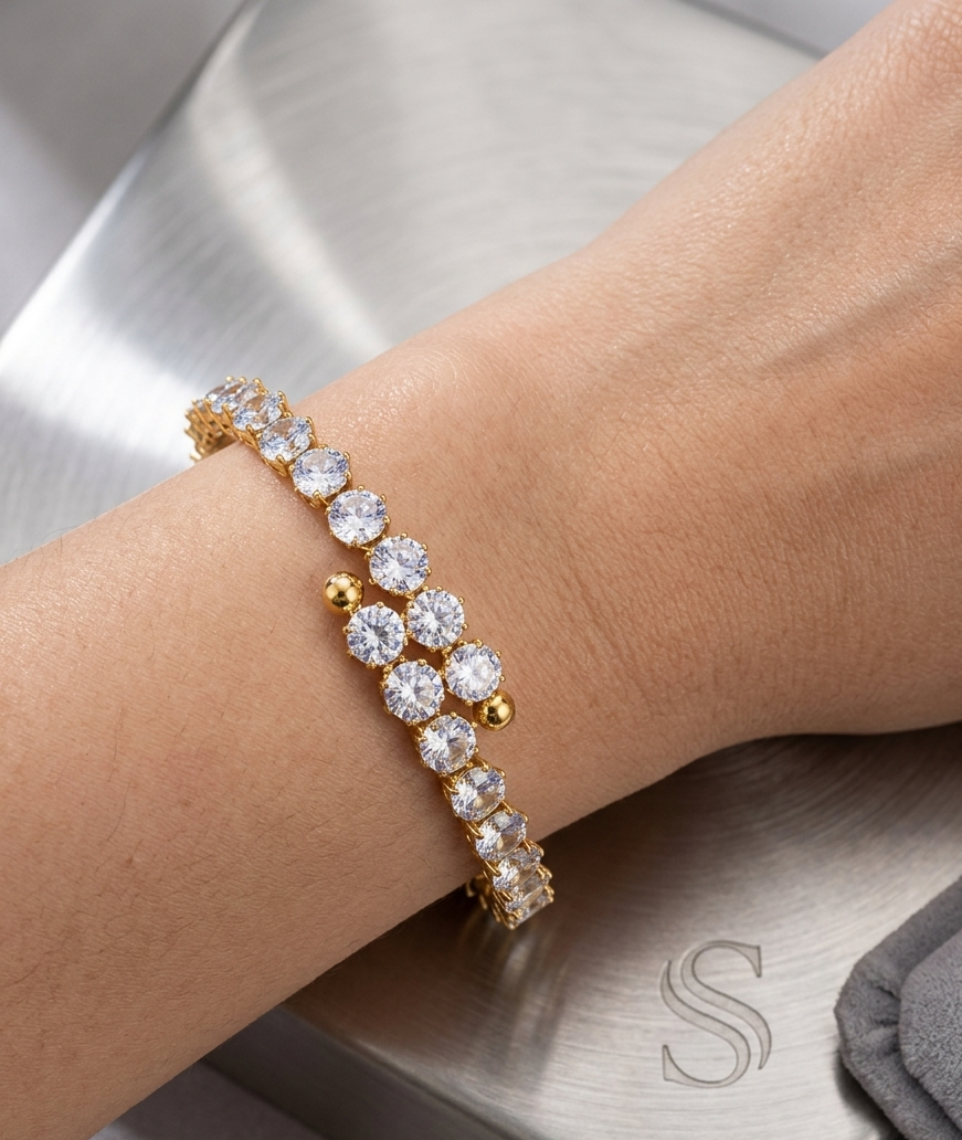 Coco pearls stainless Steel anti tarnish Gold and diamond studded bracelet on a wrist with a neutral background