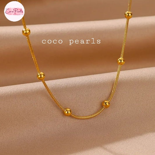 Coco pearls stainless Steel anti tarnish gold chain with balls on simple background 