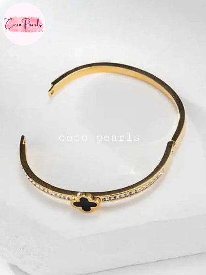 Coco pearls stainless Steel anti tarnish black clover luxe handcuff displayed on simple background 
