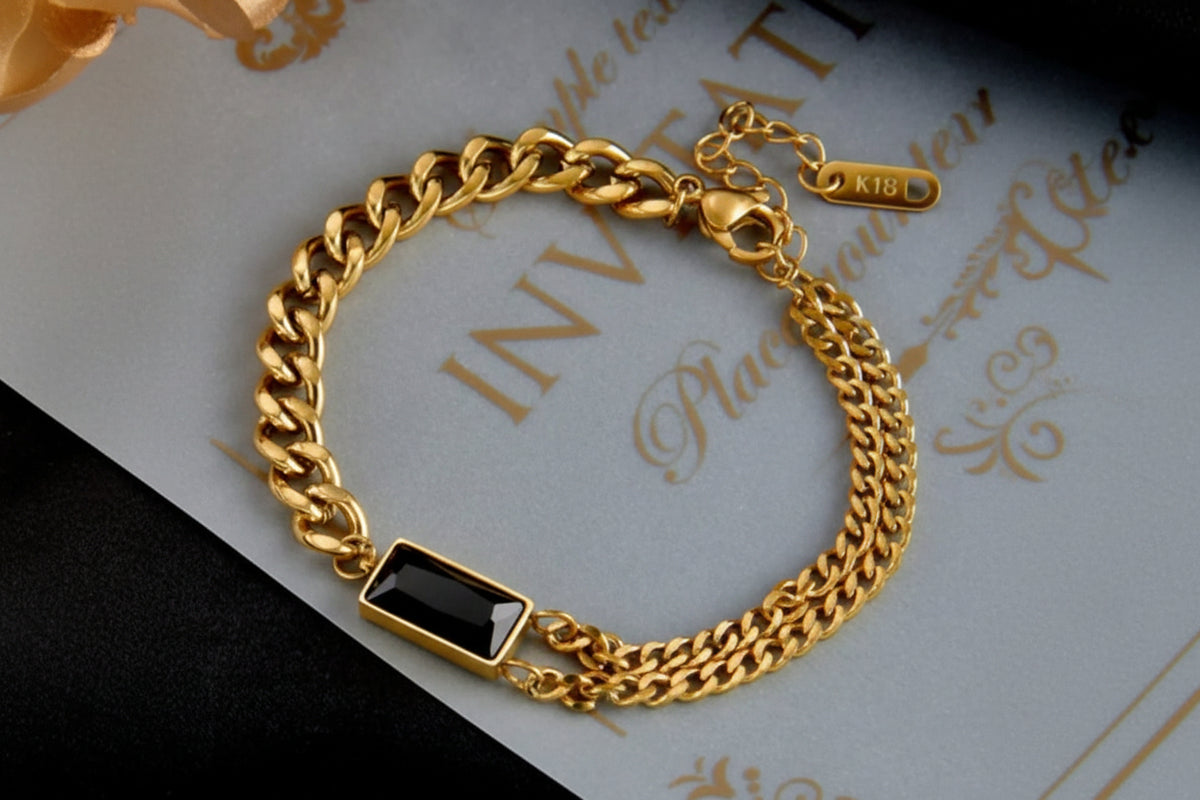 Coco Pearls Stainless Steel Anti Tarnish Gold black chain bracelet with a black gemstone on a decorative paper background