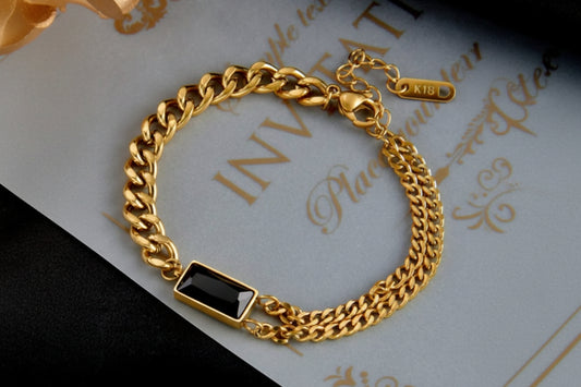 Coco Pearls Stainless Steel Anti Tarnish Gold black chain bracelet with a black gemstone on a decorative paper background