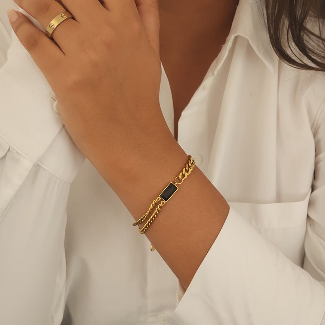 Coco Pearls Stainless Steel Anti Tarnish Gold black chain bracelet with a black stone on a wrist against a white background