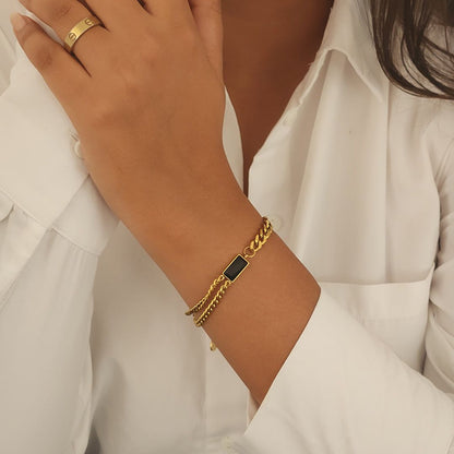 Coco Pearls Stainless Steel Anti Tarnish Gold black chain bracelet with a black stone on a wrist against a white background