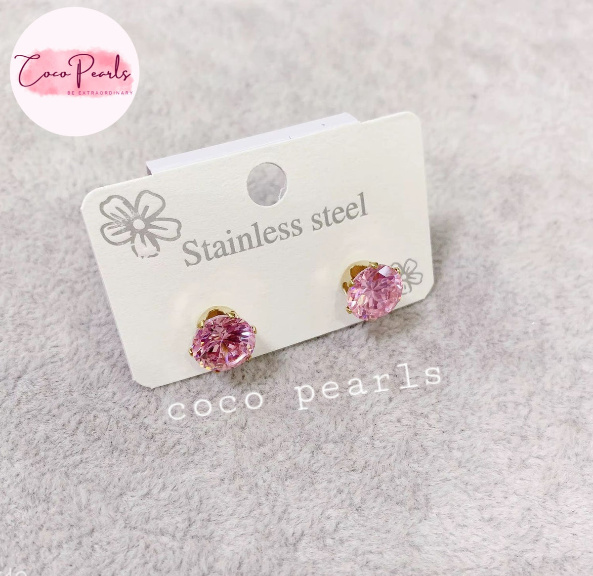 Coco pearls stainless Steel anti tarnish pair of pink pearl stud earrings in stainless steel settings, displayed on a white card