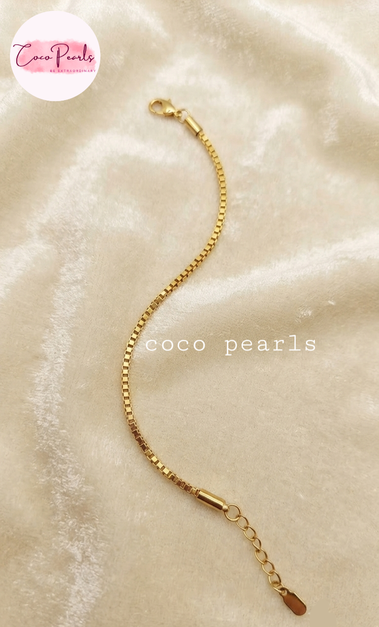 Coco pearls stainless Steel anti tarnish gold chain bracelet with a lobster clasp and extension chain, displayed on a soft beige fabric background.