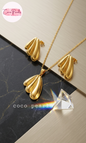 Coco pearls stainless Steel anti tarnish gold butterfly wing set with earrings and necklace on a simple background 