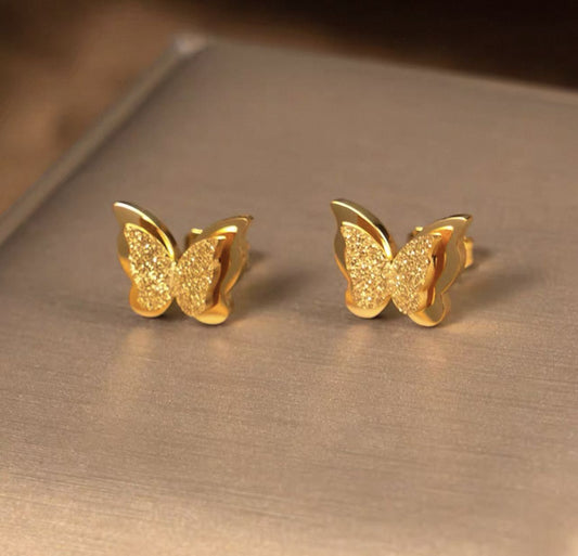 Coco pearls stainless Steel anti tarnish gold butterfly studs displayed on simple background 