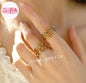 Coco pearls stainless Steel anti tarnish close-up of a hand wearing two gold-toned multi-band rings with small colorful gemstone accents, against a warm skin-toned background