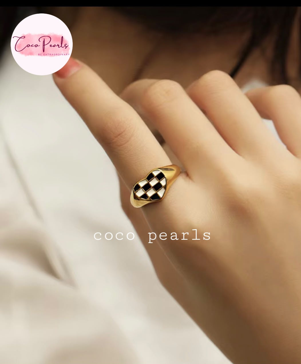 Coco pearls stainless Steel anti tarnish gold signet ring with a black and white checkered diamond face, worn on a person's finger.