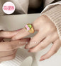 Coco pearls stainless Steel anti tarnish gold signet ring with a cherry design, worn on a person's ring finger. The ring features a polished gold band with a top plate decorated with two pink cherries on a green leaf.