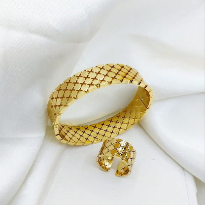 Coco pearls stainless Steel anti tarnish gold-toned woven mesh cuff bracelet with a matching small matching charm, displayed on a soft white fabric background.