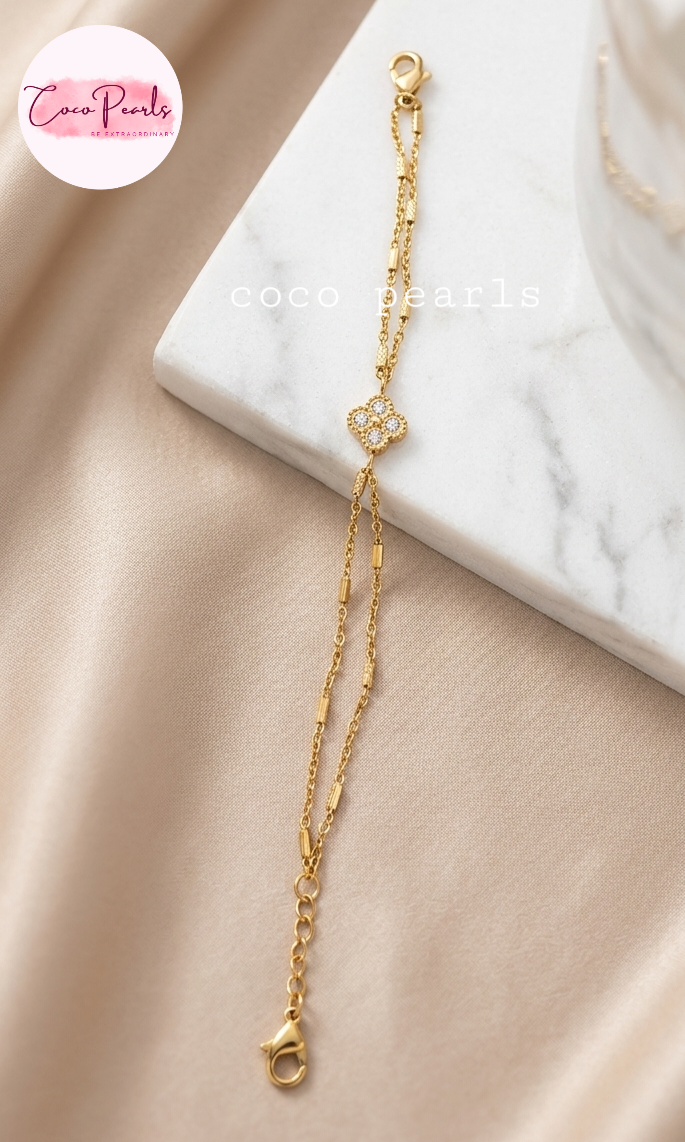 Coco pearls stainless Steel anti tarnish gold  crystal clover bracelet displayed on simple background 