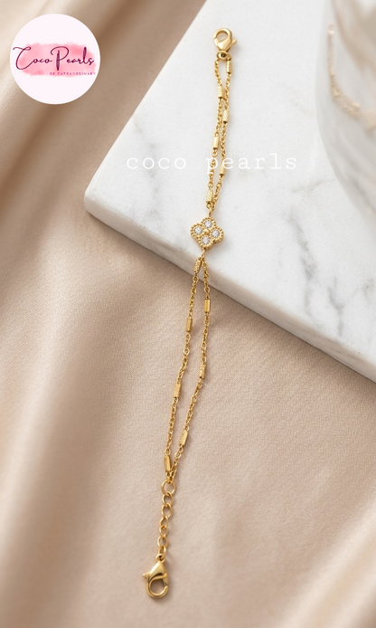 Coco pearls stainless Steel anti tarnish gold  crystal clover bracelet displayed on simple background 