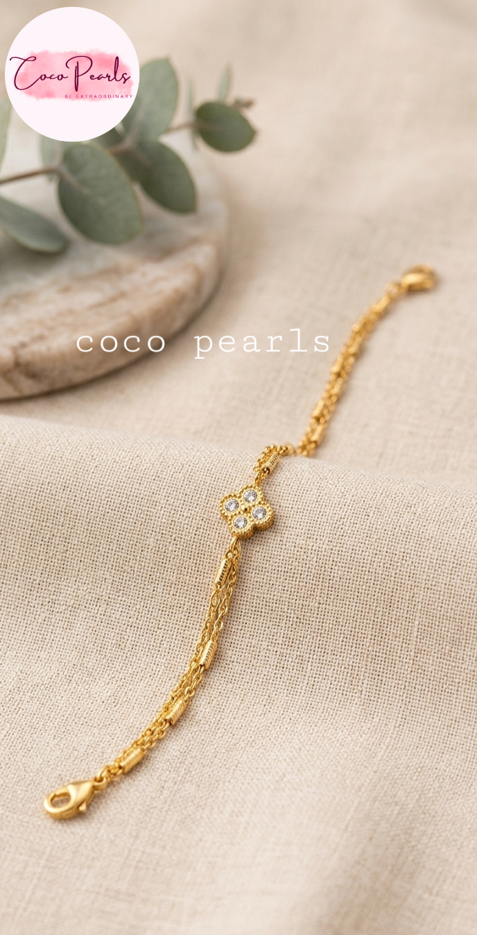Coco pearls stainless Steel anti tarnish gold crystal clover bracelet displayed on simple background 